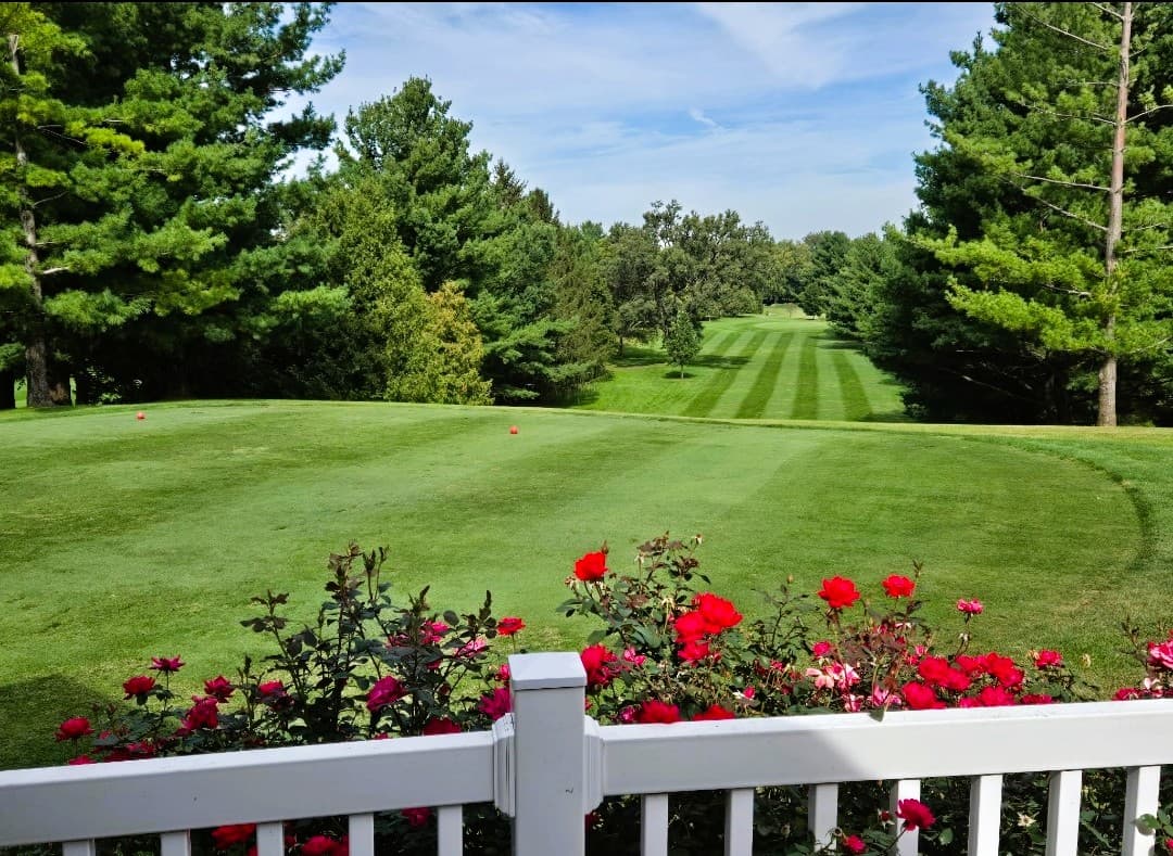 View from the first tee at La Porte City Golf Club, looking down a tree-lined fairway in summer.